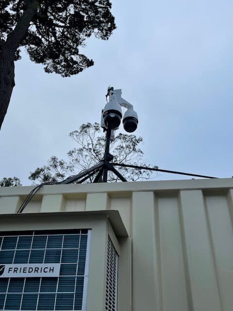 Dual PTZ surveillance cameras pole-mounted above a commercial rooftop